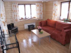 ein Wohnzimmer mit einem roten Sofa und einem Tisch in der Unterkunft Casa Nonna in Samnaun