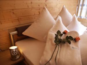 ein Bett mit weißen Kissen und einer Blume darauf in der Unterkunft Casa Nonna in Samnaun