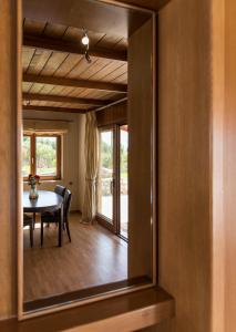 um espelho que reflecte uma sala de jantar com uma mesa e cadeiras em Athina Luxury Villas em Xamoudhokhórion