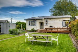a picnic table and chairs in front of a house at Bungalow on Chambers in Napier