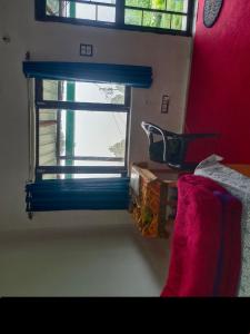 una ventana en una habitación con una pared roja en Aman Homestay, en Saur