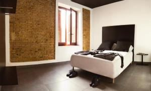 a bedroom with a bed and a brick wall at Soho Valencia in Valencia