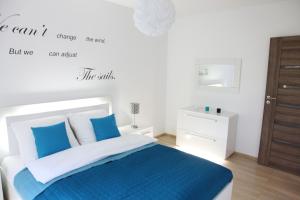 a bedroom with a blue and white bed and a mirror at Apartament Aquamarine Polanki in Kołobrzeg