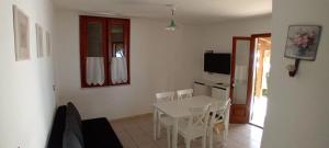 a kitchen and dining room with a table and chairs at INCANTEVOLE VILLINO SUL MARE con accesso diretto alla spiaggia, posto auto e aria condizionata! in Capoliveri