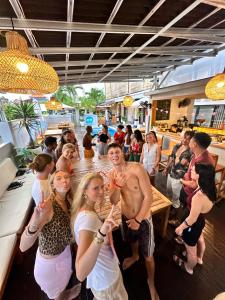 a group of people standing around a bar drinking at Surf & Party - Hostel Somewhere Else in Canggu