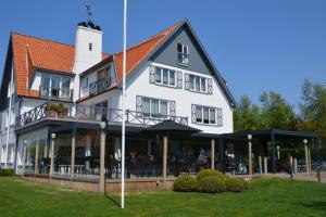 een groot wit gebouw met een openluchtrestaurant bij Lebeau 19 Hotel in Knokke-Heist