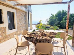 a wooden table and chairs on a patio at Stone Villa at the Vrelo in Dobra Voda