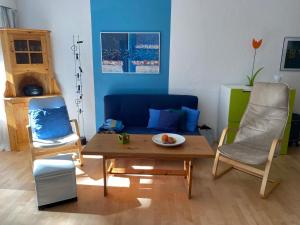 a living room with a blue couch and a table at Waldhaus - CharmingStay in Flumserberg