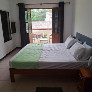 a large bed in a room with a window at Sandy Steps in Kalutara