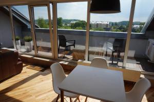 Habitación con balcón con mesa y sillas. en Napoleon Hill Apartment en Kaunas