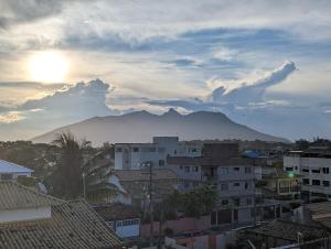 Una vista de una ciudad con una montaña al fondo. en Vista do pôr de sol, 5 min a pé da praia Tartarugas, 3 supermercados e igreja universal, super arejado, en Rio das Ostras