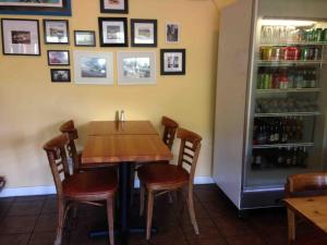 a table and chairs in a restaurant with a refrigerator at Priest Station Cafe & Cabins in Groveland