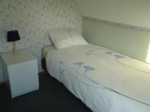 a small bedroom with a bed and a night stand at Huize Polderzicht aan het Grevelingenmeer in Battenoord