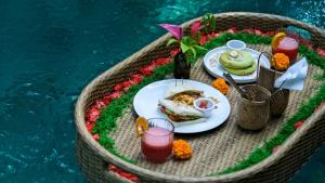 a table with plates of food and drinks in a boat at Govinda House in Penginyahan