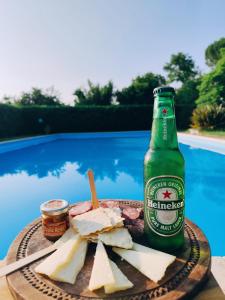 a bottle of beer and cheese on a plate next to a pool at La Tenuta Del Conte in Soriano nel Cimino