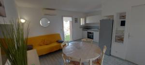 a living room with a table and a yellow couch at Residence Riviera in Porto-Vecchio