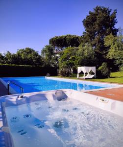 a swimming pool with a jacuzzi tub in a yard at La Tenuta Del Conte in Soriano nel Cimino