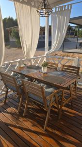 a wooden table and chairs on a wooden deck at Relaxing Mobile Home Maestral - Beach, Private Jacuzzi, Pool Access in Drage
