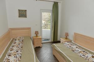 a bedroom with two beds and a window at Apartments Kuljace in Sveti Stefan