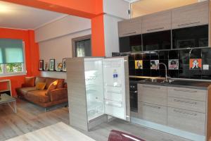 a kitchen with a refrigerator and a living room at Rino Thessaloniki Apartments in Thessaloniki