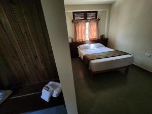 a small bedroom with a bed and a window at China Chancay Hotel in Chancay