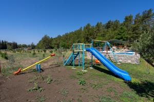 un parco giochi con scivoli in un campo con una piscina di Sora no mori village 