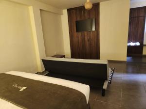 a hotel room with a bed and a flat screen tv at China Chancay Hotel in Chancay