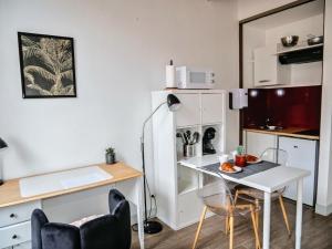 a small kitchen with a white table and chairs at La Demeure de Beauvoir - Confort & authenticité in Blois