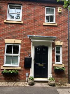 a brick house with a black door and two windows at 18 Wixon Path in Buckinghamshire
