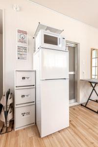 una nevera blanca con microondas encima en tkm北小岩1丁目103, en Tokio 13 fotos más