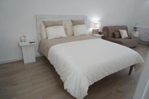 - une chambre avec un grand lit blanc et une chaise dans l'établissement FEMily B&B Bed and Breakfast di Puglia in - Bari, à Grumo Appula