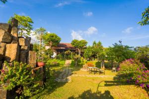 a garden with a bench and a building in the background at Vân Hòa Phú Yên homestay highland in Tuy Hoa