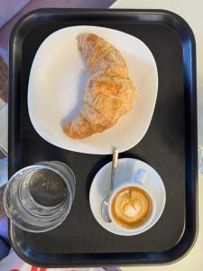 斯库台Symphony Hostel Shkoder的托盘上放着一盘糕点和一杯咖啡