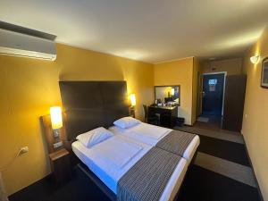 a bedroom with a large bed with yellow walls at Formula 1 Motel in Byala Ruse