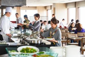 a group of people standing in a kitchen preparing food at ANA Holiday Inn Kanazawa Sky by IHG in Kanazawa