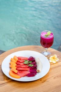 un plato de frutas y hortalizas en una mesa con una bebida en Ulu Apsura Villas, en Uluwatu 19 fotos más