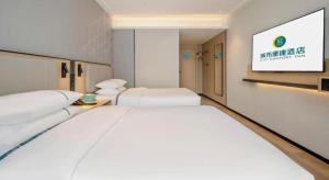 Postel nebo postele na pokoji v ubytování City Comfort Inn Nanning Guangxi University