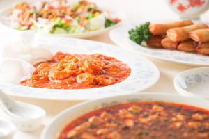 a table with plates of food and bowls of food at ANA Holiday Inn Kanazawa Sky by IHG in Kanazawa