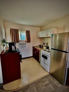 a kitchen with a stainless steel refrigerator and a stove at Caravel Motel in Swift Current +33 photos