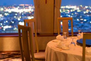 a table with plates and wine glasses and a window at ANA Holiday Inn Kanazawa Sky by IHG in Kanazawa