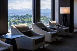 a hotel room with chairs and a large window at ANA Holiday Inn Kanazawa Sky by IHG in Kanazawa