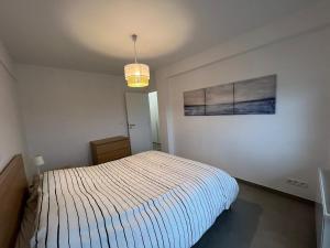 a bedroom with a bed and a painting on the wall at En Bord de Mer in Middelkerke