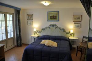 a bedroom with a blue bed and two tables at Villa Eva in Anacapri
