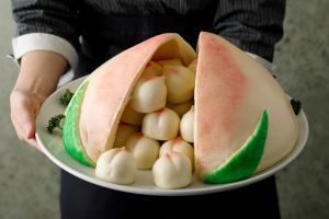 a person holding a plate with a sandwich and balls at ANA Holiday Inn Kanazawa Sky by IHG in Kanazawa