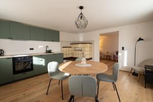 a kitchen and dining room with a table and chairs at Stilvoll sanierte Altbau-Wohnung, Dornbirn Kehlegg in Dornbirn +10 photos
