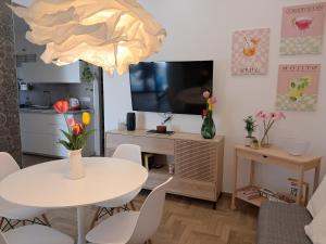 ein Wohnzimmer mit einem weißen Tisch und einem Fernseher in der Unterkunft OLTREMARE holiday home in Catania