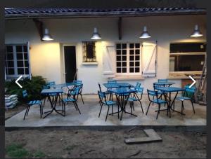 a group of blue tables and chairs in front of a building at Gîte Le pied Levé Nogaro in Nogaro