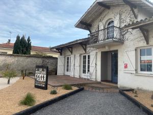 a house with a sign in front of it at Gîte Le pied Levé Nogaro in Nogaro