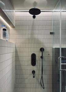 a shower in a bathroom with white tiled walls at The Erina House in Darjeeling +25 photos