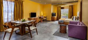 Una habitación de hotel con una cama y un comedor. en jüSTa Sajjangarh Resort & Spa, Udaipur, en Udaipur